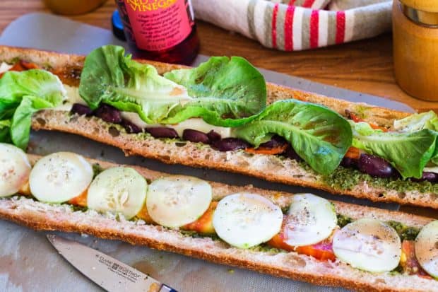 building the pan bagnat with cucumbers and lettuce with red wine vinegar bottle