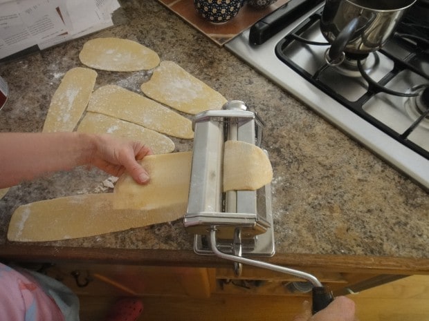 Rolling homemade Lemon Pasta with a hand crank pasta machine