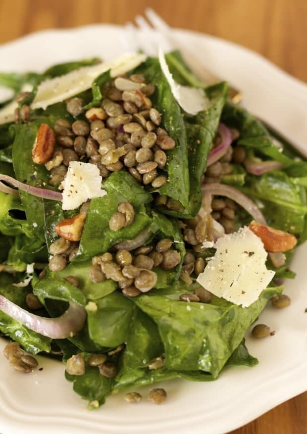 closeup shot of Wilted Spinach and Green Lentil Salad on a white plate