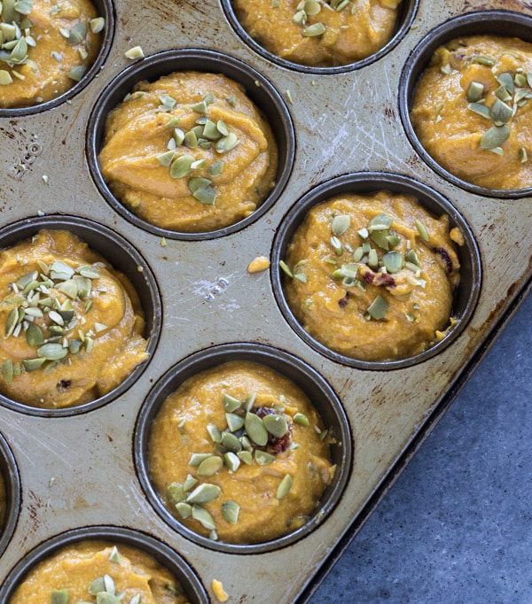 unbaked Spiced Maple Cranberry Pumpkin Muffins in muffin tins