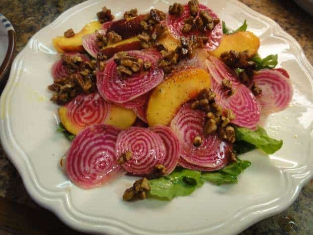 Plated and ready to eat Chioggia Beet, Arugula, Peach and Candied Pecan Salad
