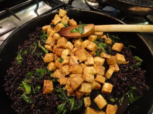 Lacquered Tofu with in skillet over black rice and green mix