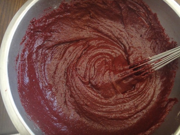 Mixed beet cookie batter whisked in metal bowl
