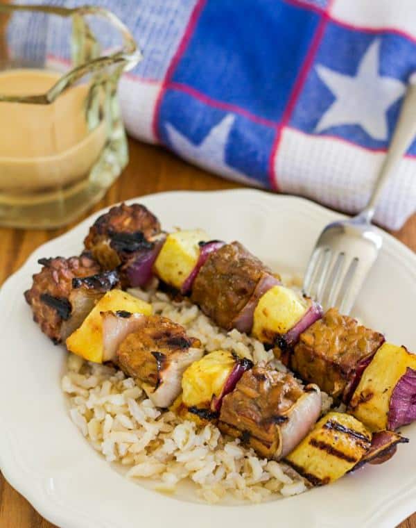 Tempeh and Pineapple Kebabs on top of rice with Satay sauce on the side