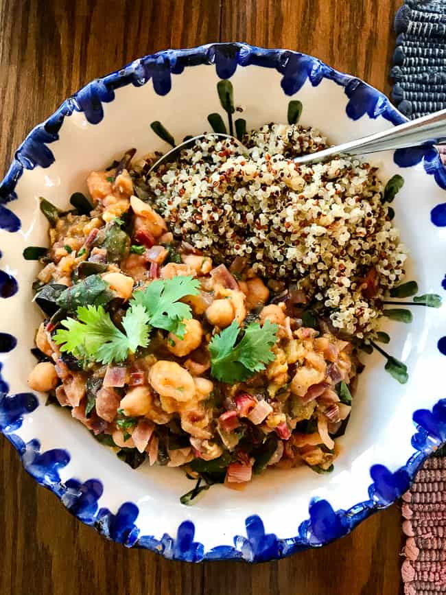 Chard and chickpea curry with quinoa in blue-edge bowl