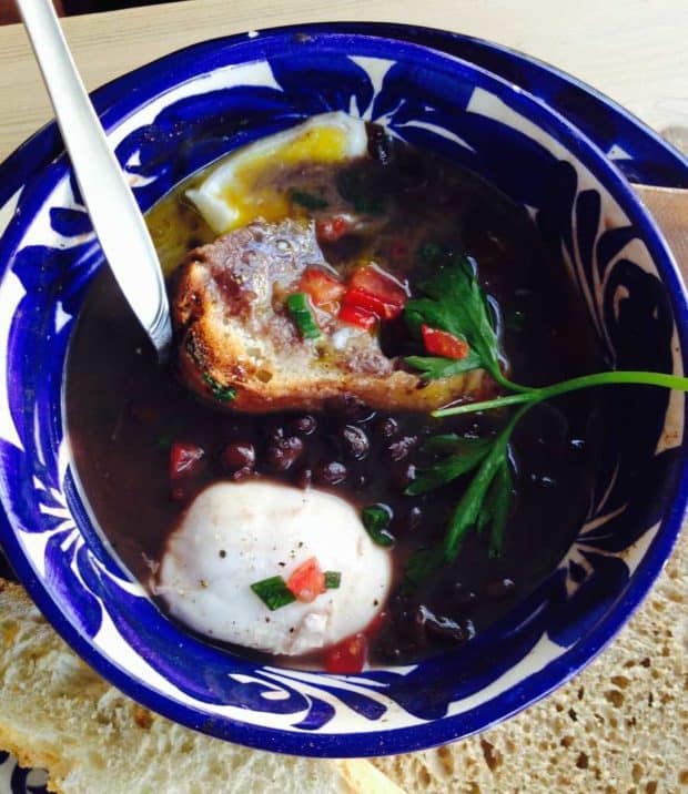 Black Bean Soup with Poached Egg and Salsa in a blue pottery bowl