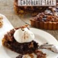 Maple walnut chocolate tart slice with full tart in background, with title text for Pinterest