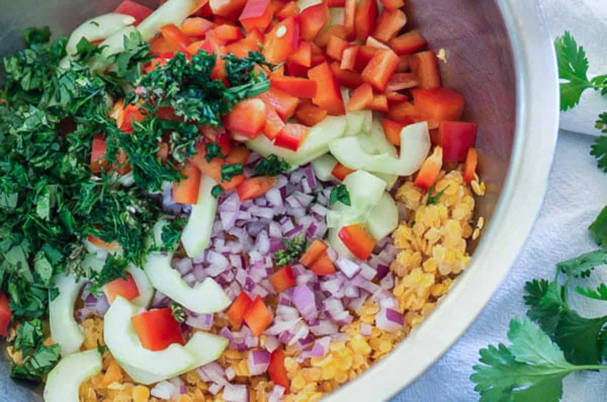 red lentil confetti salad ingredients all in a bowl ready to mix