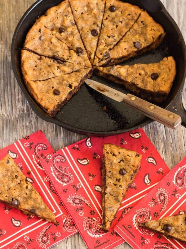 Skillet Chocolate Chip Walnut Cookie with cut pieces on handkerchief red napkins| Letty's Kitchen