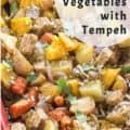 baked vegetables and tempeh in red casserole dish with text for Pinterest