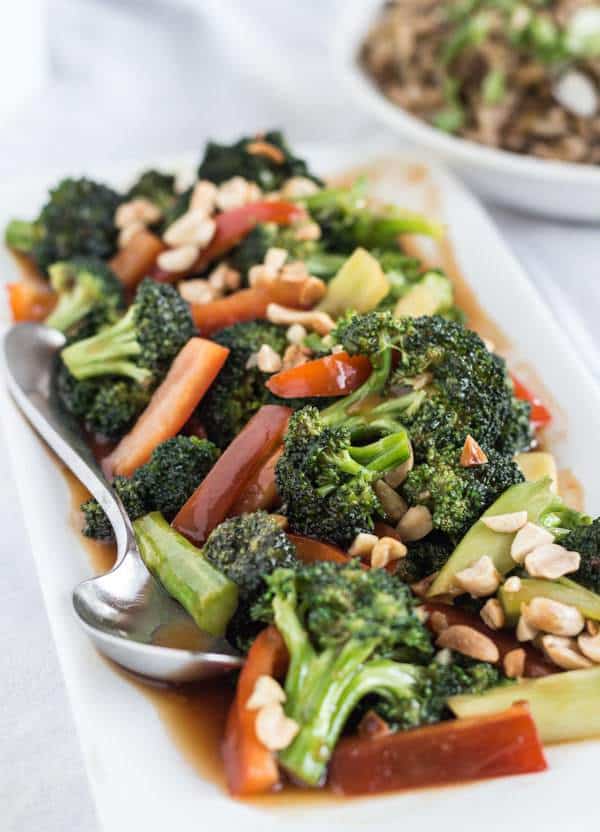 Easy Sweet and Sour Broccoli with Peanuts on rectangular platter with spoon