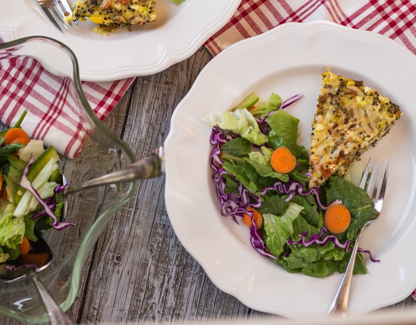 Rainbow Quinoa Egg Bake plated with salad bowl on the table