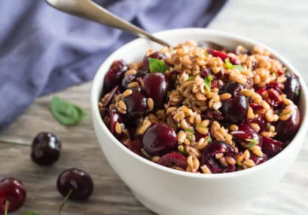 spoon in bowlfull of Cherry and Farro Salad with Pressure-Cooked Farro