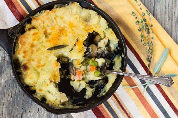Shepherd’s Pie in a skillet with portions already served so the filling under the potato crust is visilble.
