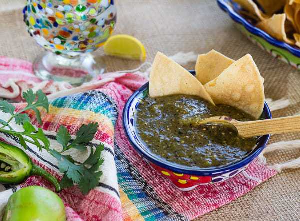 Homemade Roasted Green Tomatillo Salsa with tortilla chips and tequila snifter