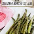 Roasted Asparagus on white plate with chimichurri sauce with text for Pinterest