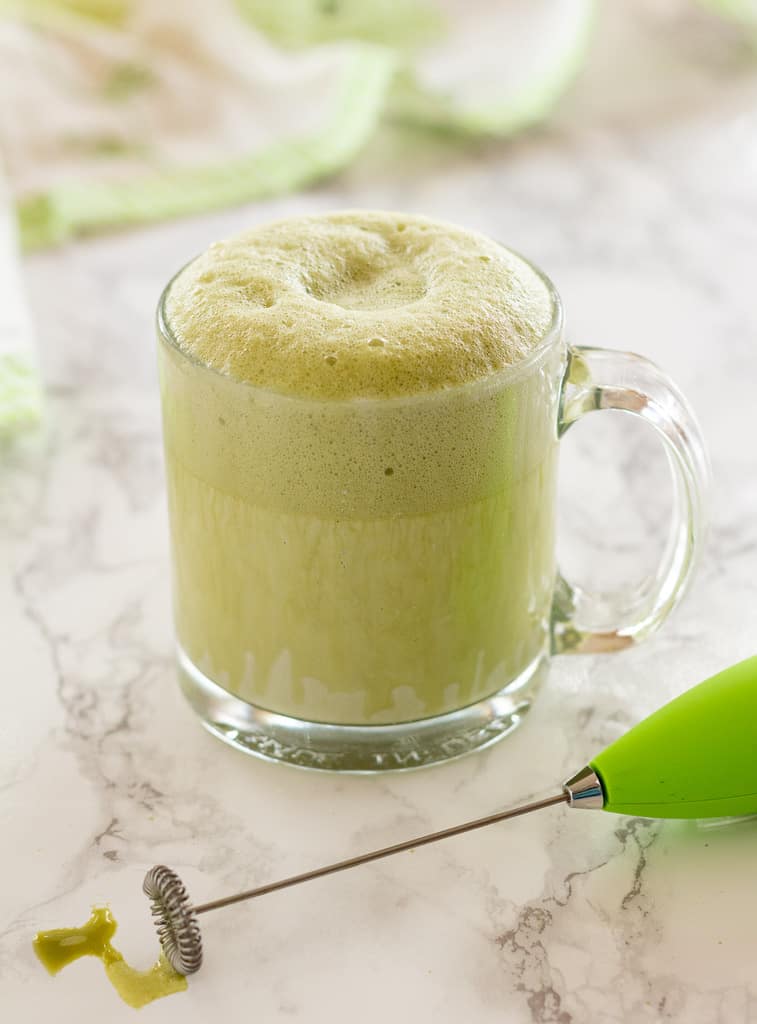 clear glass mug of green foamy hot matcha oat milk latte