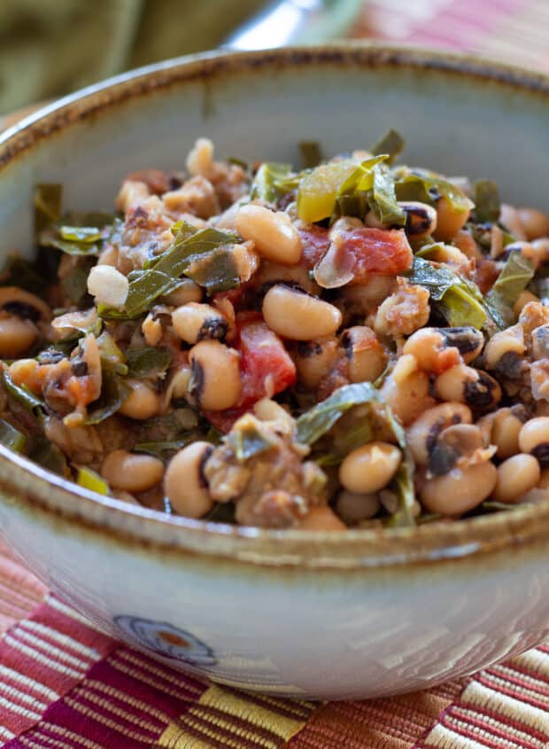 Closeup shot of Black-eyed peas and greens stew in blue bowl